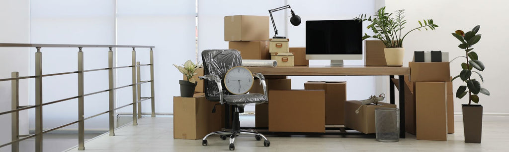 Commercial eviction depiction with boxes and equipment packed near a desk