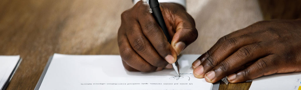 person signs the bottom of a business contract